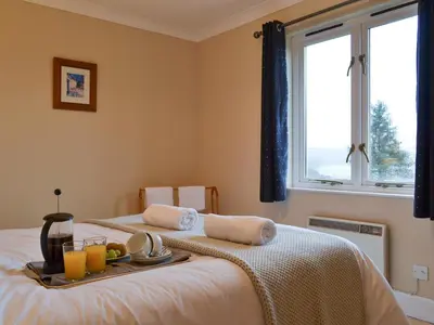 a bedroom with a bed with a tray of food on it at Tigh An Aighear in Arduaine