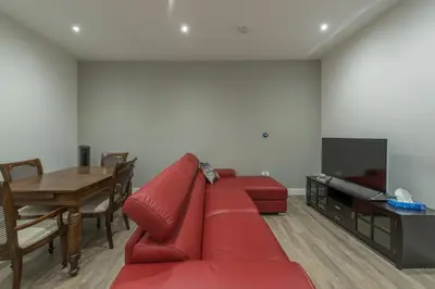 a living room with a red couch and a table at Haymarket Spacious 3 Bedroom Street Level in Edinburgh