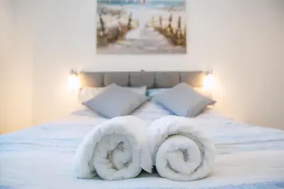 two towels are made to look like swans on a bed at Marina View Guest House in Irvine