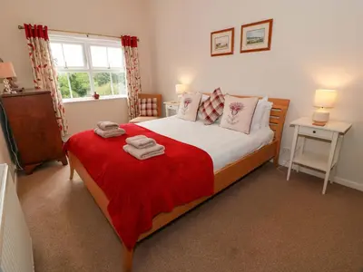 a bedroom with a large bed with a red blanket at Cairnhill in Girvan