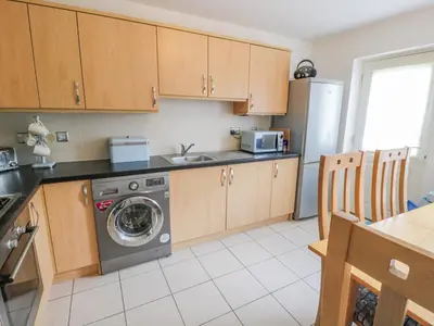 a kitchen with a washer and a sink and a refrigerator at Bright and Beautiful in Ayr