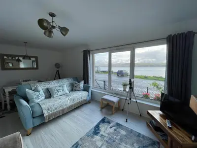 a living room with a couch and a large window at Pier View in Dunoon