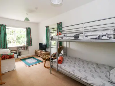 a bedroom with two bunk beds and a living room at Tower Lodge in Dalmally