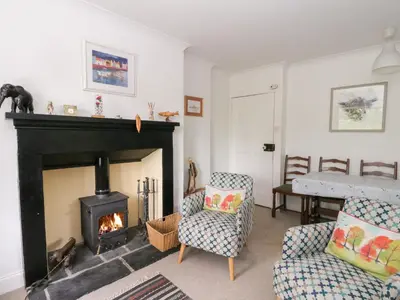 a living room with a fireplace and a couch and a chair at Tower Lodge in Dalmally