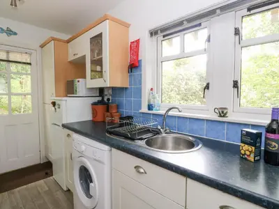 a kitchen with a sink and a washing machine at Tower Lodge in Dalmally