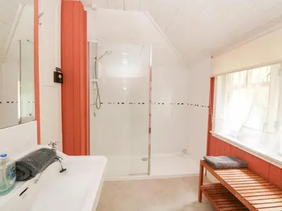 a bathroom with a shower and a white tub at Tower Lodge in Dalmally