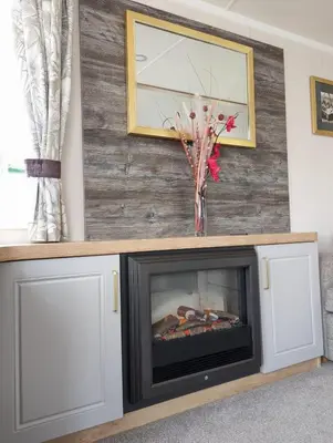 a fireplace in a living room with a tv at Swift Bordeaux Sea View 15 in Dunoon