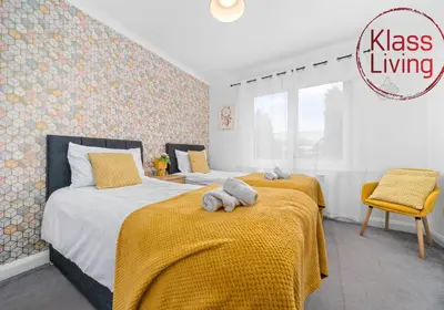 a bedroom with two beds with yellow blankets and yellow sheets at Anderson Apartment by Klass Living Motherwell in Motherwell