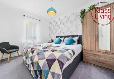 a bedroom with a large bed and a chair at Anderson Apartment by Klass Living Motherwell in Motherwell