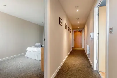 a hallway leading to a bedroom in a house at Modern Riverfront Apt. 10 mins from Hydro/SECC in Glasgow