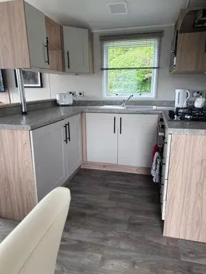 a kitchen with white cabinets and a sink at The Manor Sea View 1A in Ardentinny