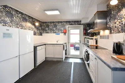 a kitchen with white cabinets and a counter top at Lochans Lodge in Stranraer