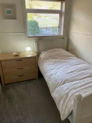 a bedroom with a bed and a dresser and a window at Dumbarton With A View in Dumbarton