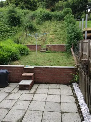 a garden with a brick retaining wall and stairs at Dumbarton With A View in Dumbarton
