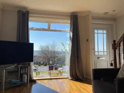 a living room with a large window and a television at Dumbarton With A View in Dumbarton