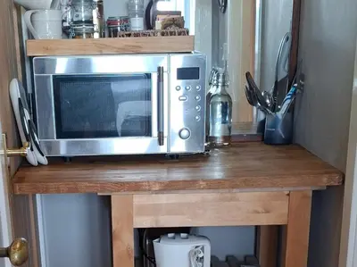 a microwave on a wooden counter in a kitchen at Black Stair Room - En Suite in Helensburgh