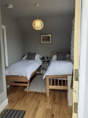 a bedroom with two beds and a chandelier at Black Stair Room - En Suite in Helensburgh