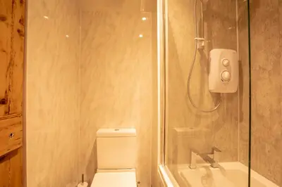 a bathroom with a shower with a toilet and a sink at Black Stair Room - En Suite in Helensburgh