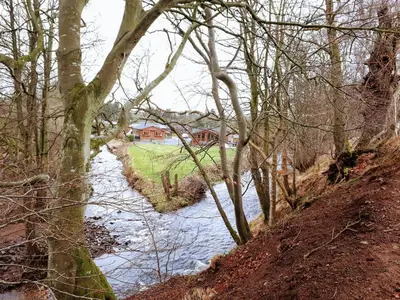 a view of a river with a house in the background at Grandeagles Extra large lodge in Auchterarder