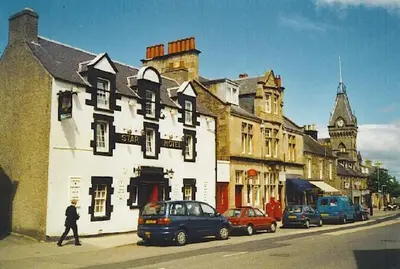 a man walking down a street next to a building at Grandeagles Extra large lodge in Auchterarder