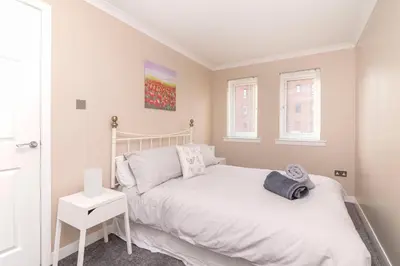 a bedroom with a white bed and a window at The Cluthar - Ground Floor West End City Centre Rockvilla flat & Parking in Glasgow