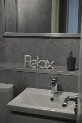 a bathroom with a white sink and a mirror at The Cluthar - Ground Floor West End City Centre Rockvilla flat & Parking in Glasgow