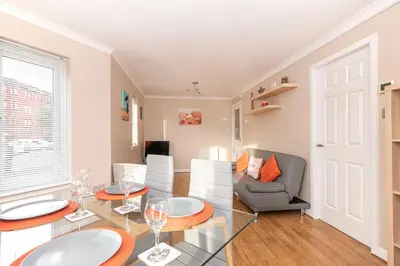 a living room with a glass table and chairs at The Cluthar - Ground Floor West End City Centre Rockvilla flat & Parking in Glasgow