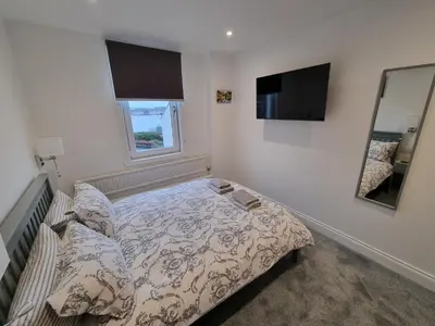 a small bedroom with a bed and a mirror at Cala Sith Guesthouse in Port Ellen