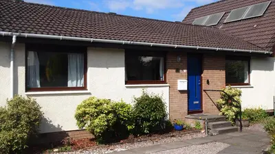 a white house with a blue door at Skerryvore in Oban