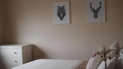 a bedroom with a bed and two pictures on the wall at Skerryvore in Oban