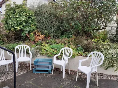 a group of three chairs sitting next to a garden at Skerryvore in Oban