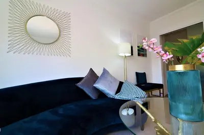 a living room with a blue couch and a mirror at Signature - Macneish House East Kilbride in East Kilbride