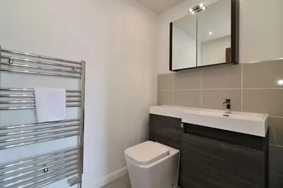 a bathroom with a toilet and a sink and a mirror at Signature - Macneish House East Kilbride in East Kilbride