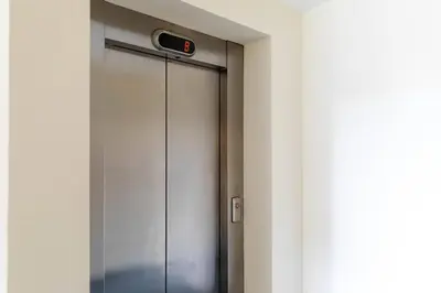 a metal door with a security camera on it at Modern 2 bed BroomPark/Central apt. with Parking in Glasgow