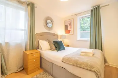 a bedroom with a bed and a window at Merchant City Glasgow Green Apartment With Parking in Glasgow