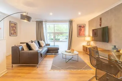 a living room with a couch and a table at Merchant City Glasgow Green Apartment With Parking in Glasgow