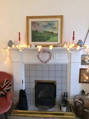 a living room with a fireplace with christmas lights at 5 star beautiful & vintage, spacious apt in chic location! in Edinburgh