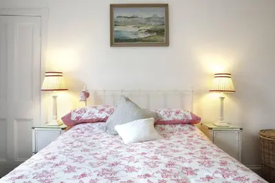 a bedroom with a bed with two lamps on it at 5 star beautiful & vintage, spacious apt in chic location! in Edinburgh