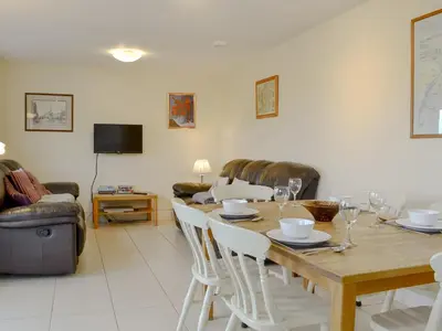 a living room with a wooden table and chairs at Carribber Beech in Torphichen