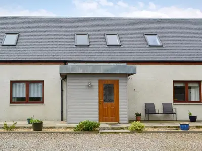 a white house with a brown door and windows at Carribber Beech in Torphichen