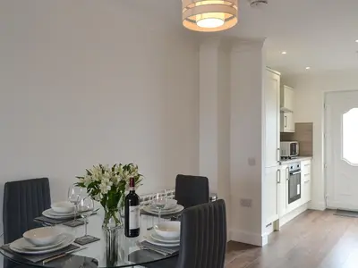 a dining room with a glass table and black chairs at Sealladh Alainn in Oban