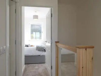 a hallway with a bedroom with a bed and a window at Sealladh Alainn in Oban