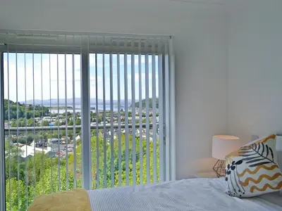 a bedroom with a bed and a large window at Sealladh Alainn in Oban