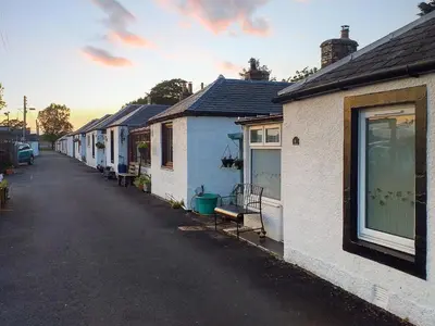 a row of houses lined up on a street at Honeysuckle Cottage in Springside