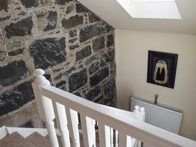 a staircase with a stone wall and a stair case at Lochearnside Lodge in Saint Fillans
