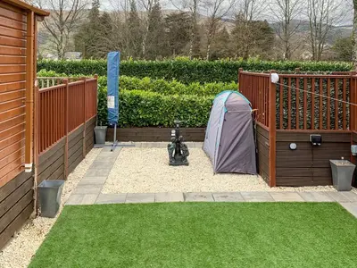 a garden with a tent next to a fence at Bridge End Lodge in Dollar