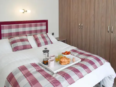 a tray of food on top of a bed at Bridge End Lodge in Dollar