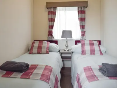 two twin beds in a room with a window at Bridge End Lodge in Dollar