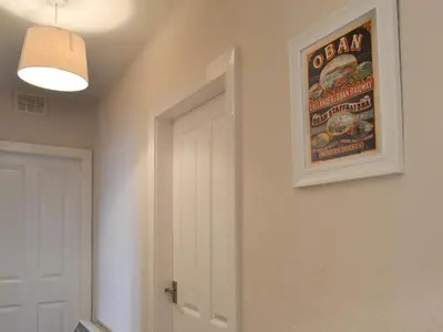 a picture on a wall with a poster on it at Finlaggan Apartment in Oban