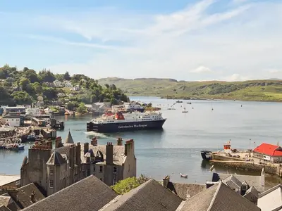 a large boat in the water near a town at Finlaggan Apartment in Oban
